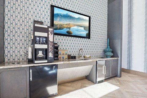 A modern kitchen with a stainless steel refrigerator and a large painting on the wall.
