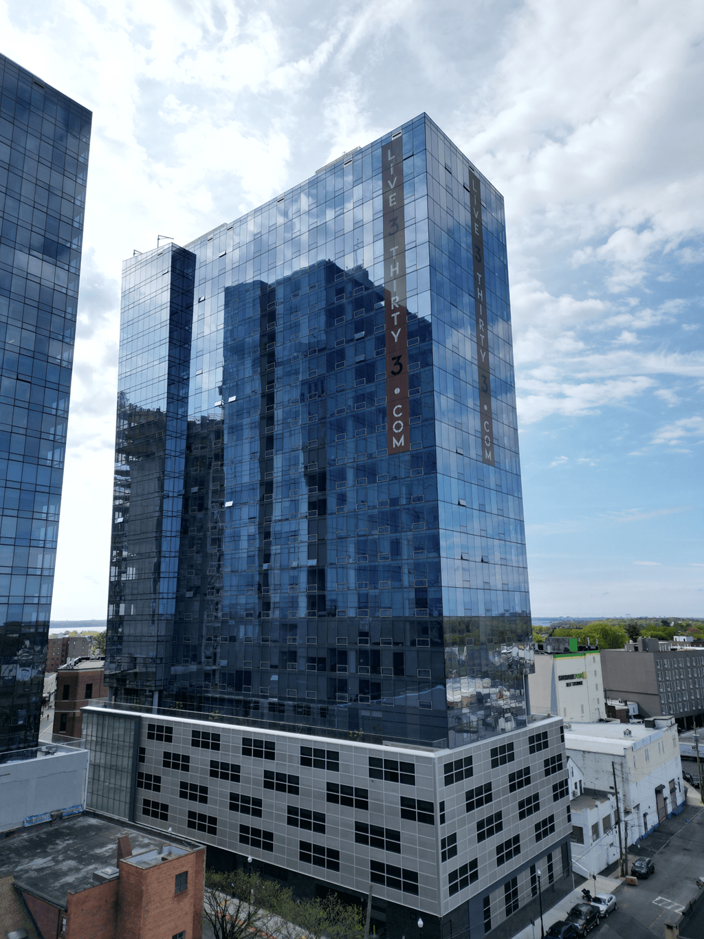 a tall blue building in the middle of a city