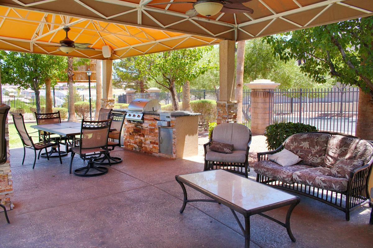 Pet-Friendly Apartments In Henderson, NV - Avalon At Seven Hills - Shaded Barbeque Area At The Pool With Tables, Chairs, And Fans
