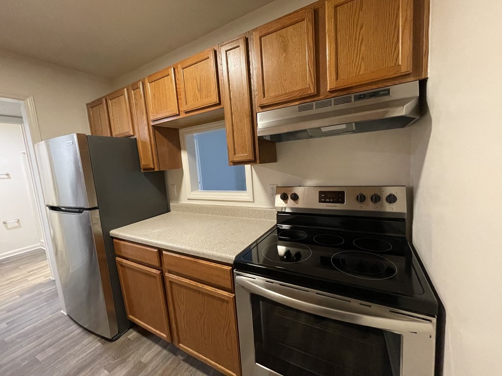 an empty kitchen with a stove and a refrigerator