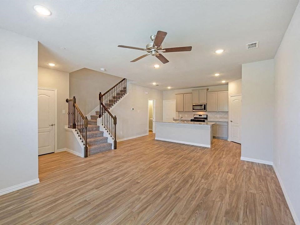 an open living room and kitchen with a ceiling fan