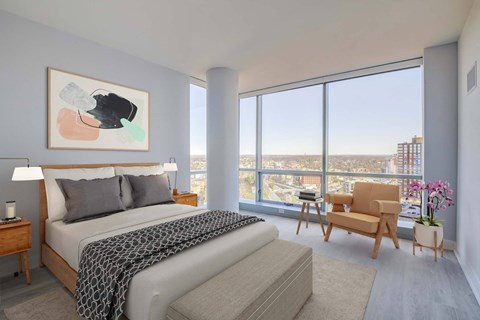 a bedroom with a bed and a view of the city