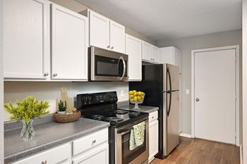 a kitchen with white cabinets and stainless steel appliances