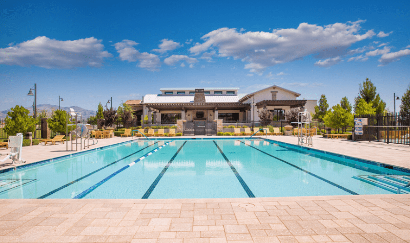 a swimming pool with a house in the background