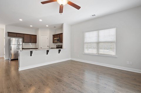 Harris Trail Luxury Townhomes for rent Richmond Hill, GA photo of an empty living room hardwood floors and a ceiling fan