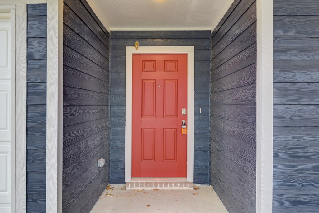 the front door of a blue house with a red door