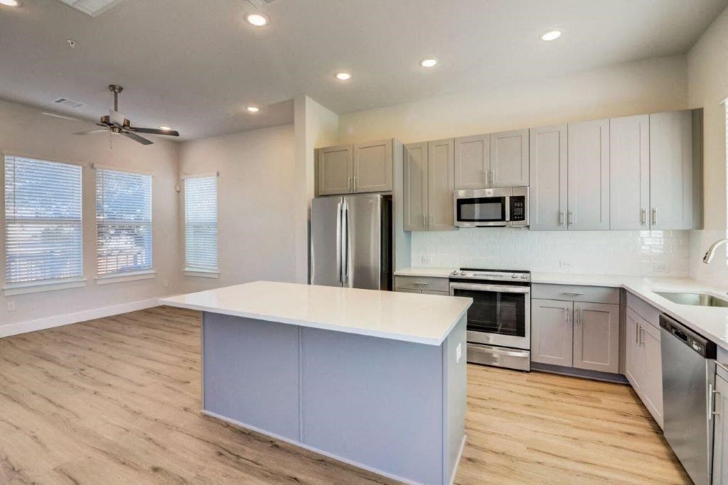 an empty kitchen with white cabinets and a white counter top