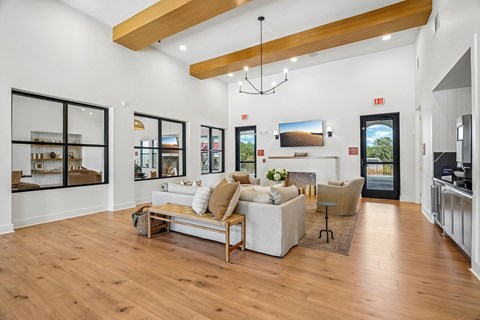 A spacious living room with a white couch and a wooden floor.