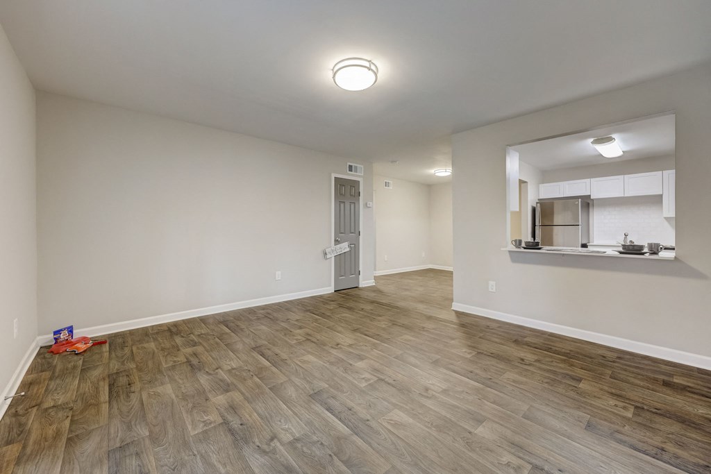 Sandy Springs, GA Apartments – Celebration at Sandy Springs -  the living room and kitchen in a new home with wood flooring