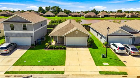 A residential area with houses and cars.