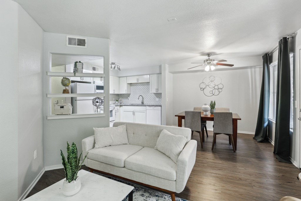 A living room with a white couch and a ceiling fan.