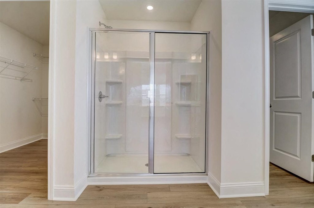 a walk in shower with a glass door in a bathroom