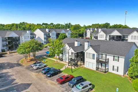 A parking lot with cars and apartment buildings in the background.