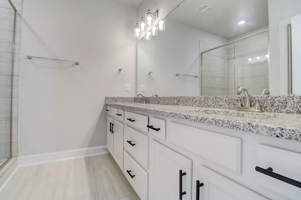 a bathroom with white cabinets and granite countertops