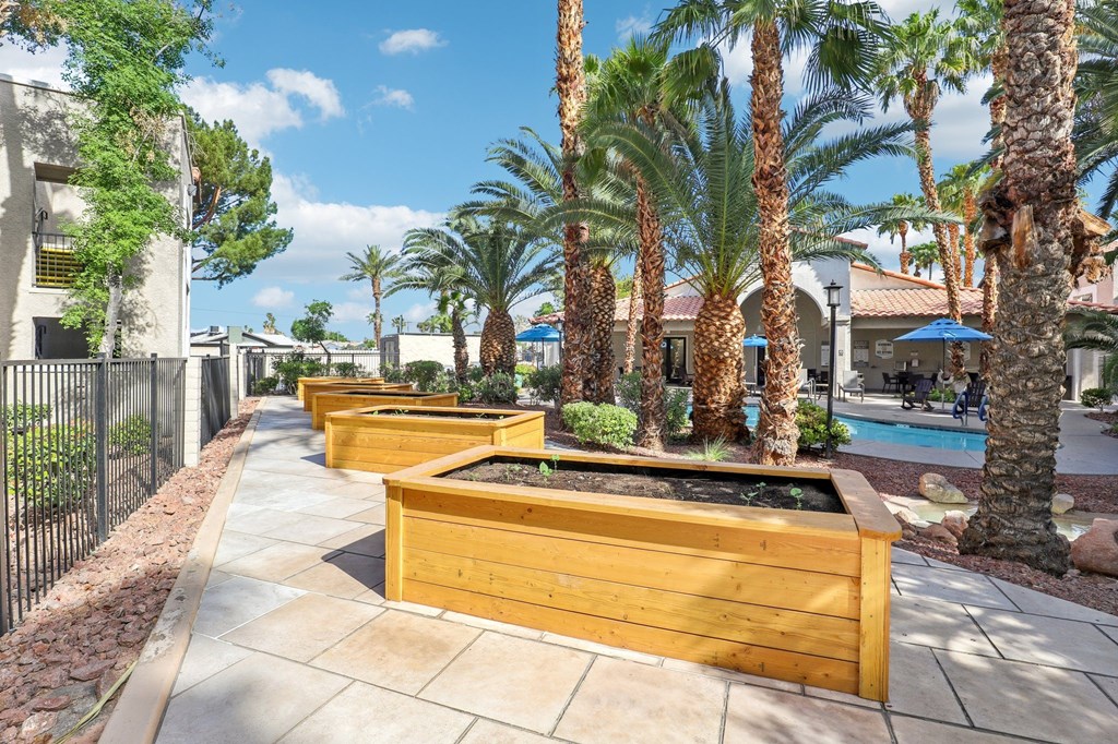 A row of wooden planters are lined up on a sidewalk.