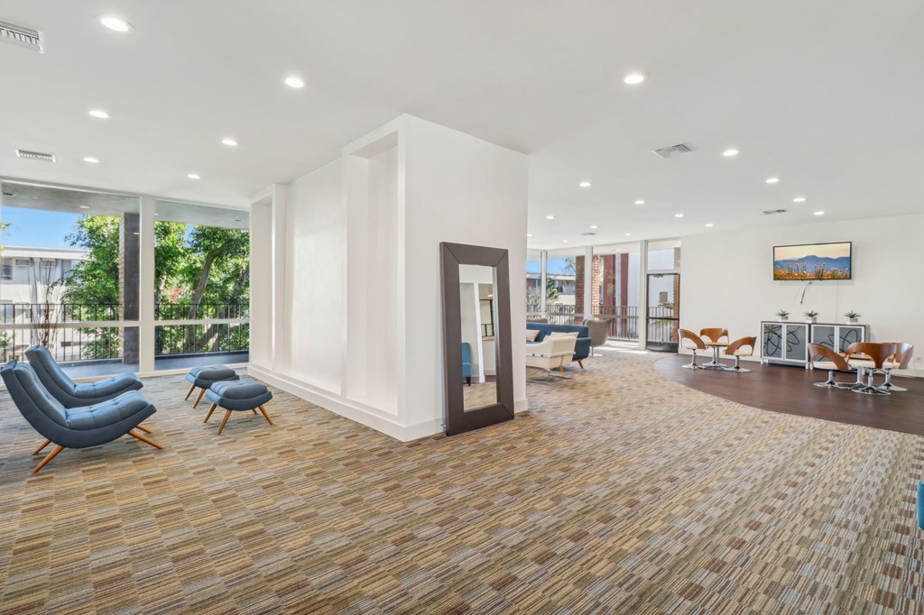 A spacious waiting room with a view of the outdoors through large windows.