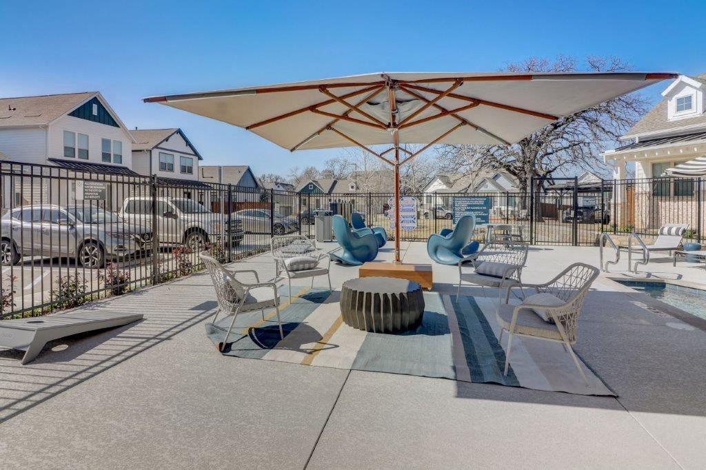 a large patio with chairs and an umbrella