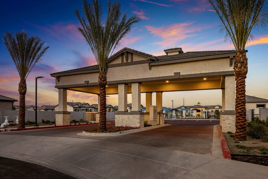 A building with palm trees in front of it during sunset.