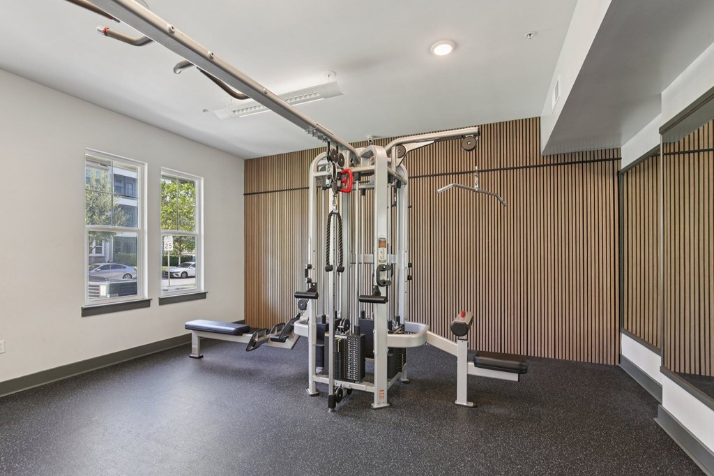 Gym area featuring free weights and workout benches at Lotus at Starkey Ranch in Odessa, Florida.
