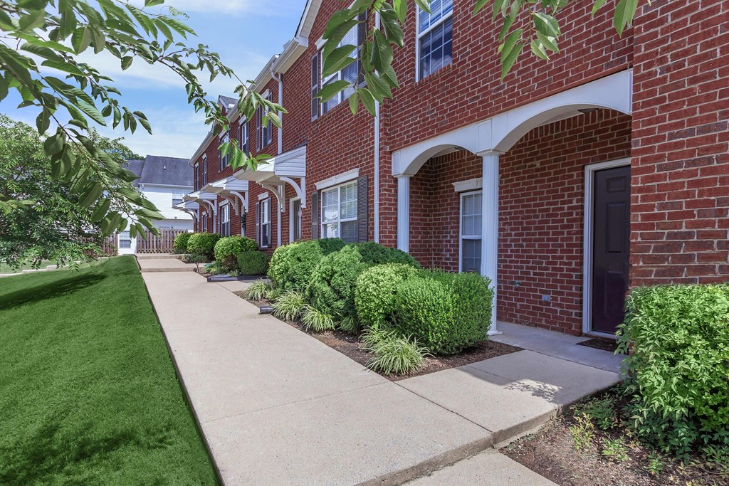 a sidewalk in front of a brick building
