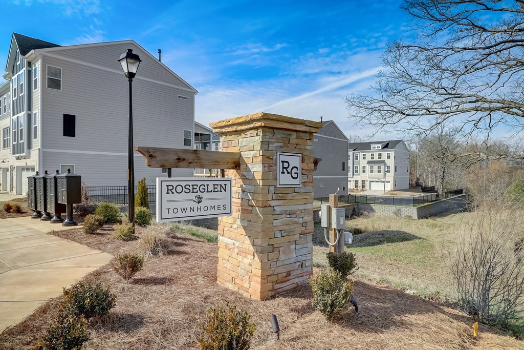 a sign that says rosehill townhomes in front of a house