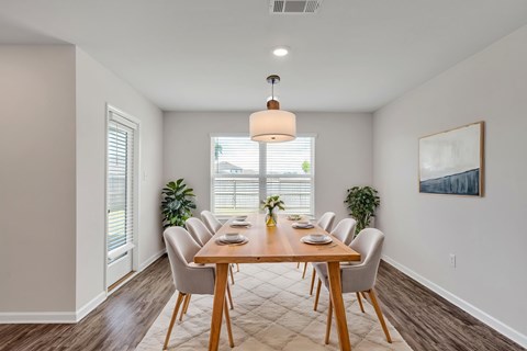 A dining room with a wooden table and chairs.