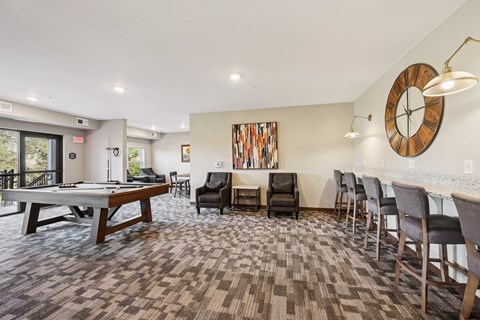 A room with a pool table and a couch.