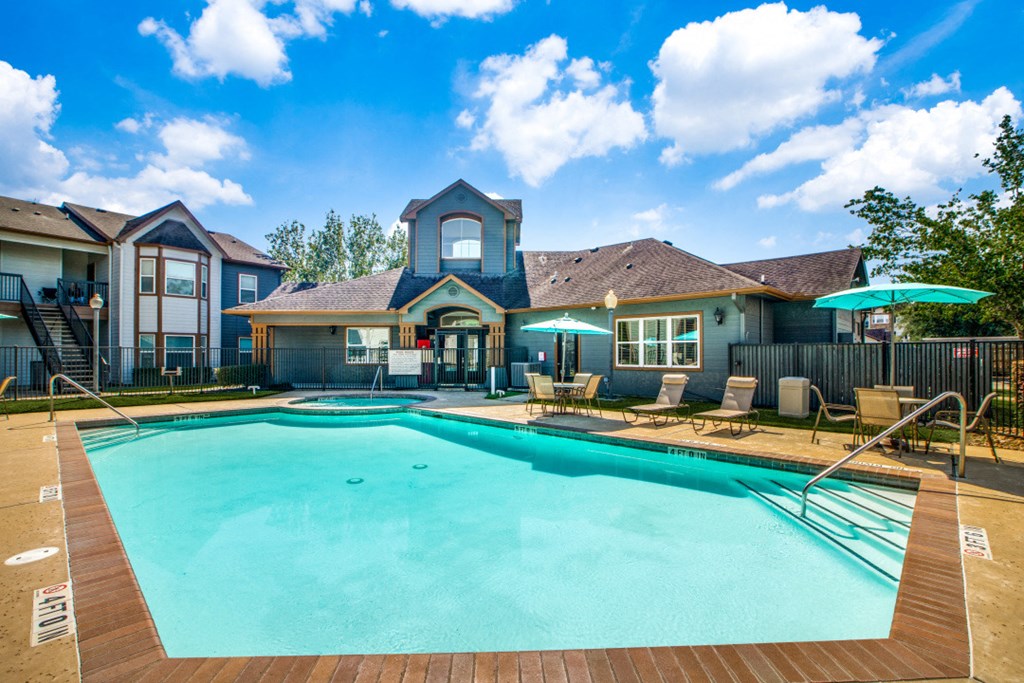Pet-Friendly Apartments in Beaumont, TX – Breakwater Bay - swimming pool with umbrellas and beach chairs