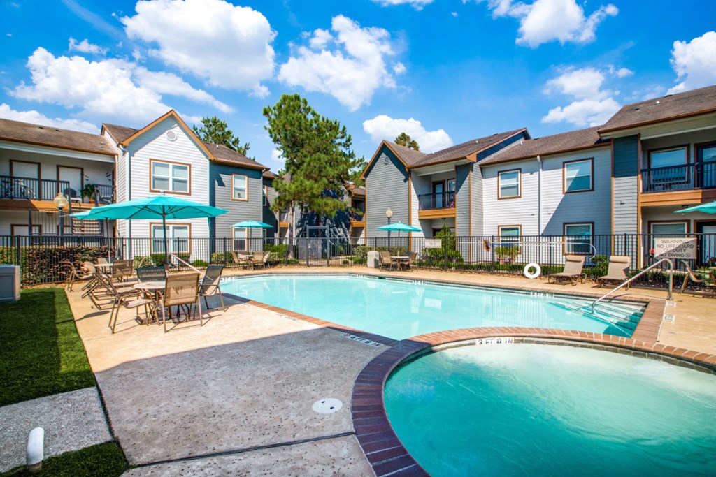 Pet-Friendly Apartments in Beaumont, TX – Breakwater Bay - swimming pool with umbrellas and beach chairs