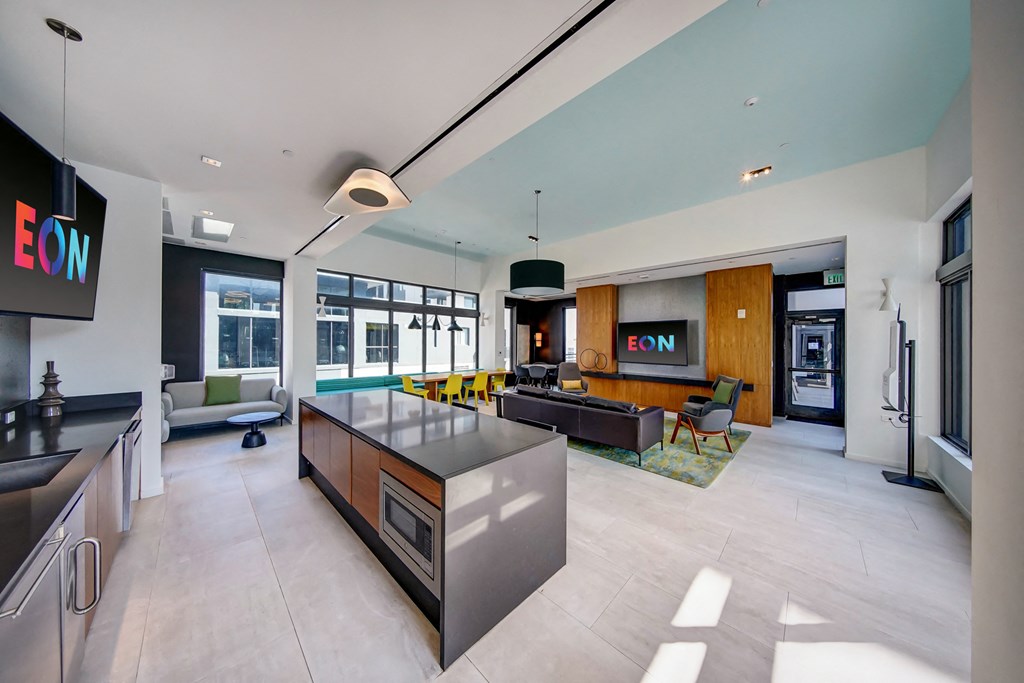 a kitchen with a large island in the middle of a room with a living room