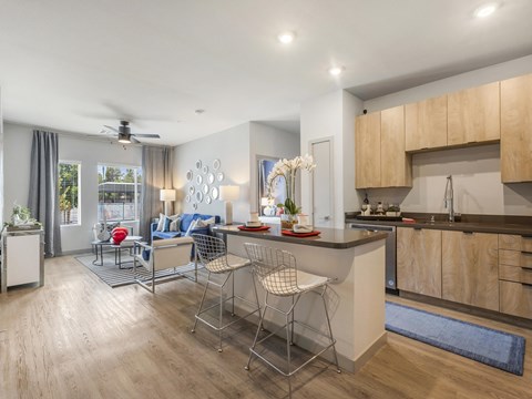 A modern kitchen with a dining area and a living room.