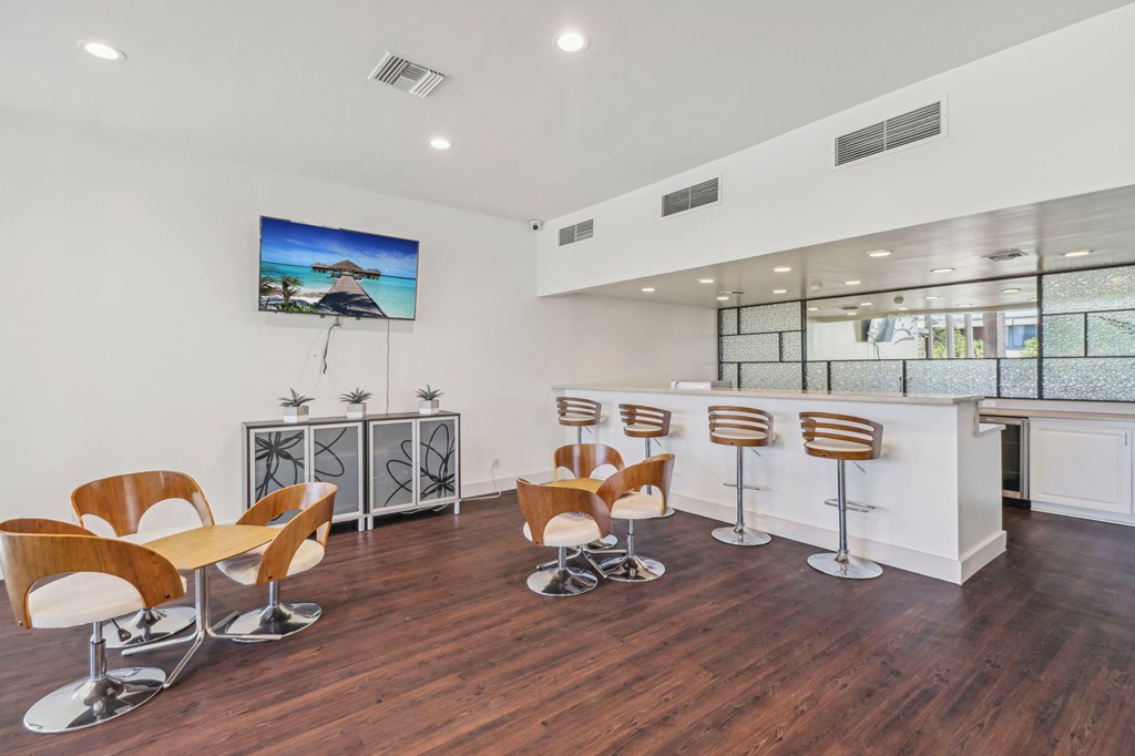 A modern room with a bar and chairs.