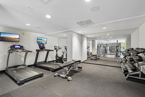 A gym with treadmills, exercise bikes, and other equipment.