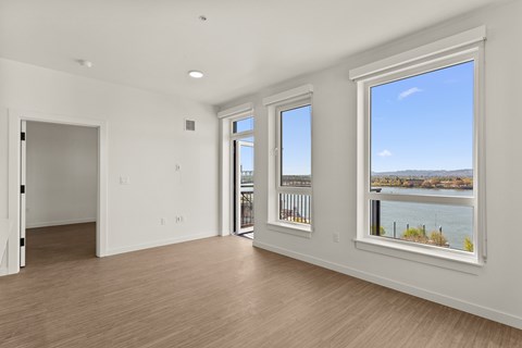 A spacious room with a view of the water through the window.