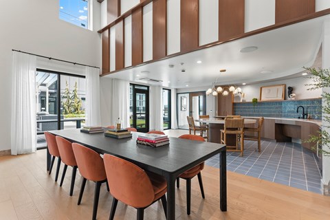 A modern dining room with a long table and chairs.