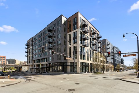 A large building with many windows is on the corner of a street.
