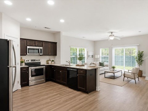 A modern kitchen with dark brown cabinets and stainless steel appliances.
