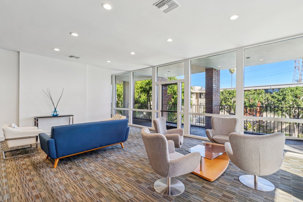 A living room with a blue sofa and a glass wall.