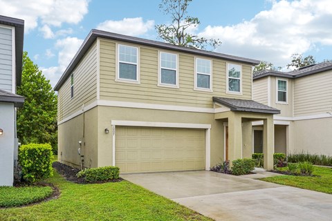 A beige house with a white garage door.