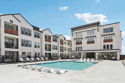 A large white building with a pool in front.