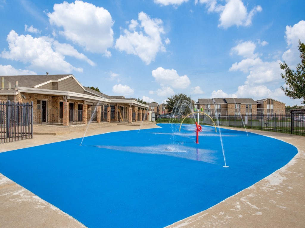 Outdoor splash pads with water features at Monarch Pass in Fort Worth, Texas, near South Fort Worth.