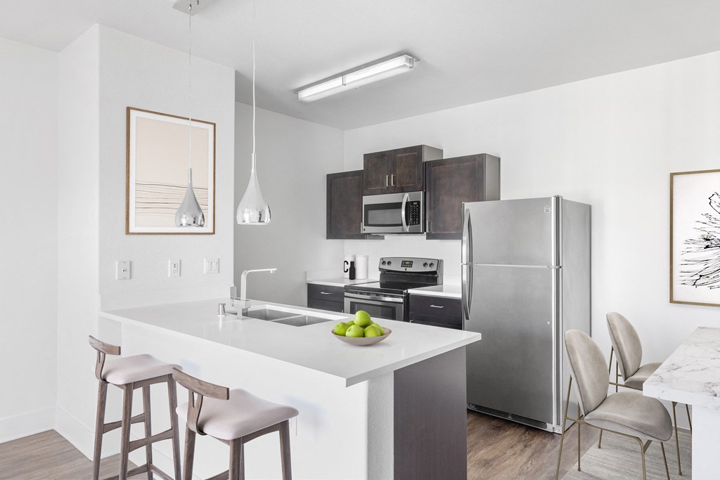 a kitchen with a island and a stainless steel refrigerator