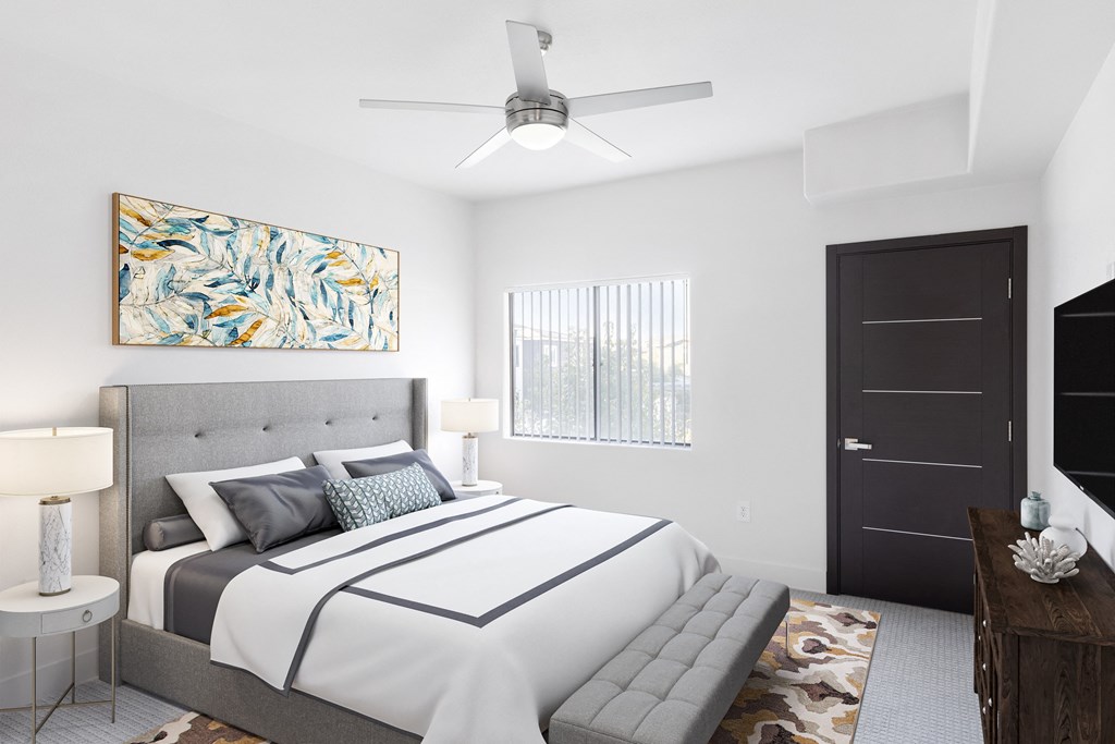 a white bedroom with a large bed and a ceiling fan