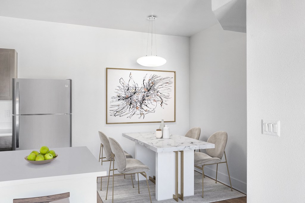 a dining room with a marble table and a kitchen with a refrigerator