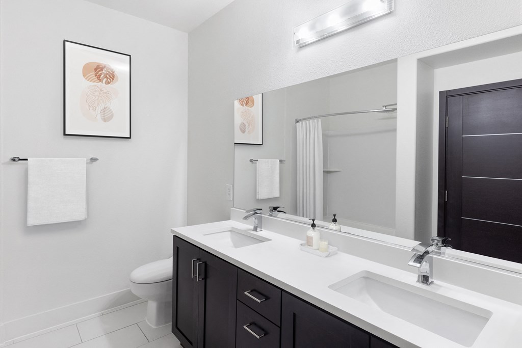 a white bathroom with two sinks and a mirror
