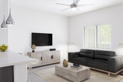 a living room with a black couch and a tv
