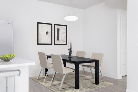 a dining room with a black table and white chairs