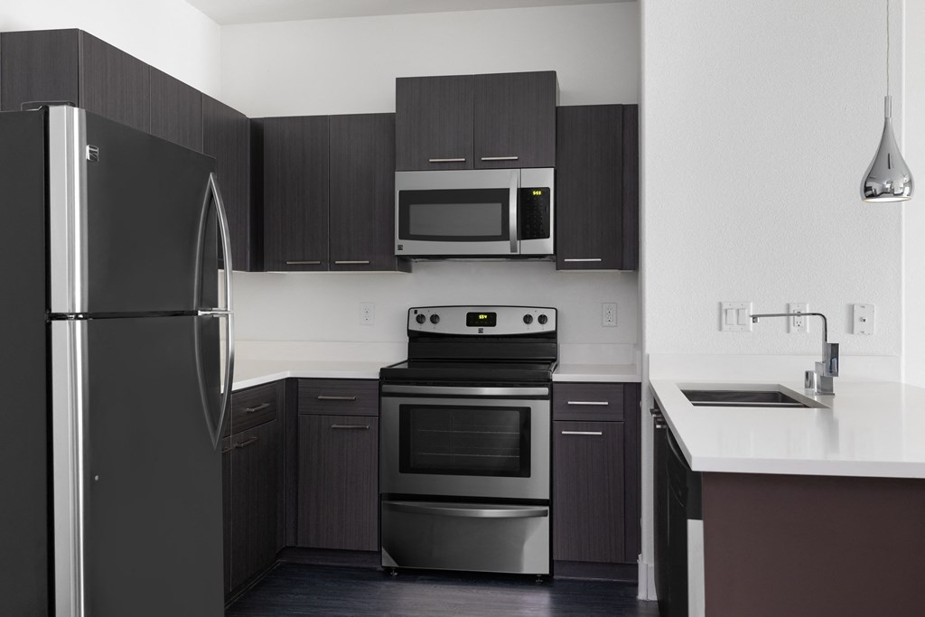 a kitchen with stainless steel appliances and black and white cabinets
