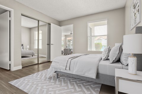A bedroom with a large bed and a patterned rug.
