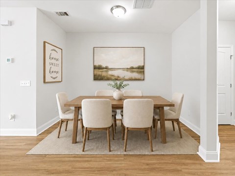 A dining room with a wooden table and chairs.